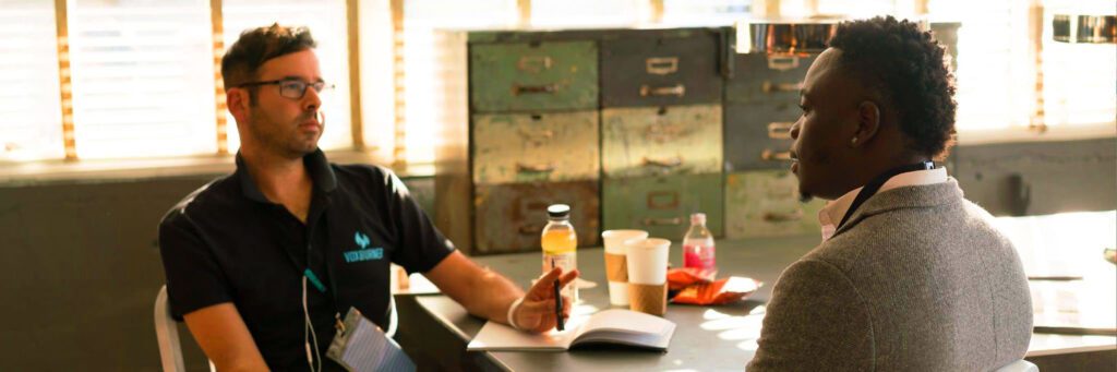 A person sitting at a table with some food and drinks.